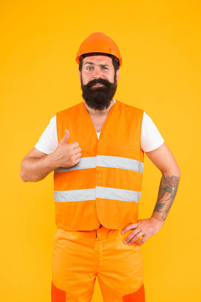 Confident in building. Confident constructor. Bearded man worker showing thumbs up with confident look. Happy builder or architect with confident smile on yellow background - 写真・画像