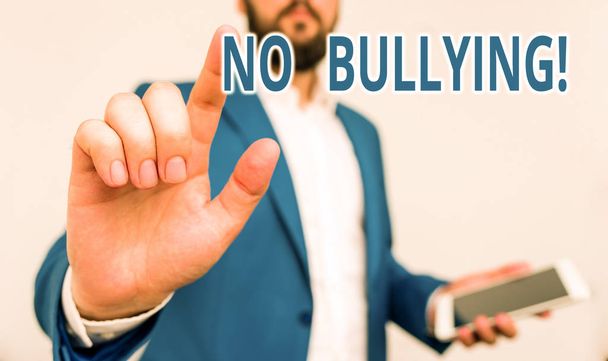 Conceptual hand writing showing No Bullying. Business photo showcasing stop aggressive behavior among children power imbalance Businessman pointing with pen in empty copy space. - Photo, Image