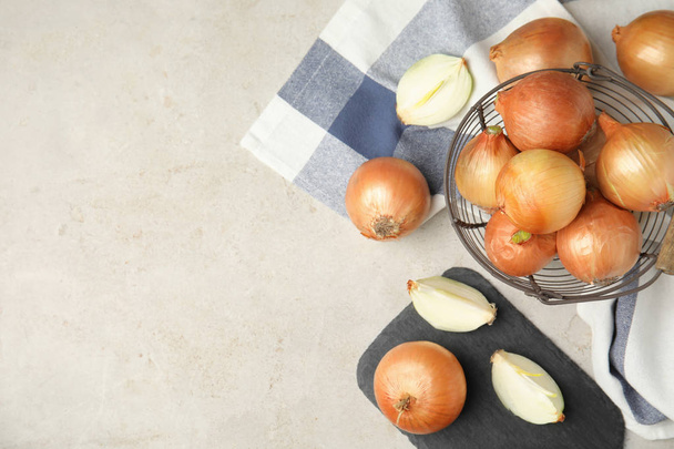 Flat lay composition with ripe onions on grey table, space for text - Foto, Bild