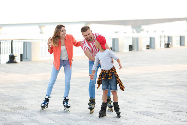 Happy family roller skating on city street - Foto, Imagem