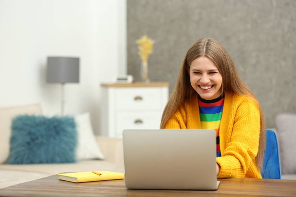 Ευτυχής νεαρή γυναίκα παίζοντας online λοταρία χρησιμοποιώντας το laptop στο σπίτι - Φωτογραφία, εικόνα