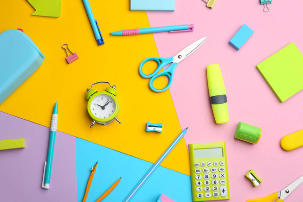 Different bright school stationery on color background, flat lay - Foto, immagini