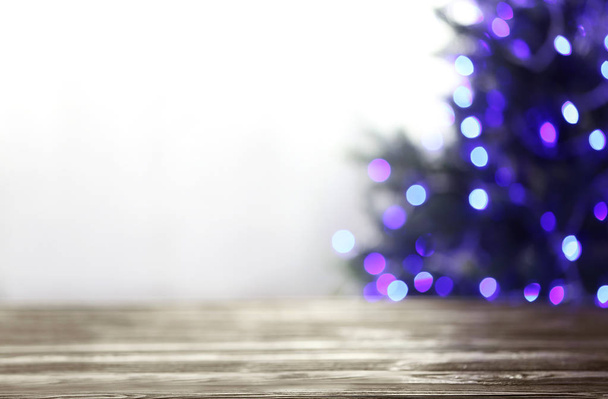 Arka planda mor Noel ışıkları ile boş masa ve bulanık köknar ağacı, bokeh etkisi. Tasarım alanı - Fotoğraf, Görsel