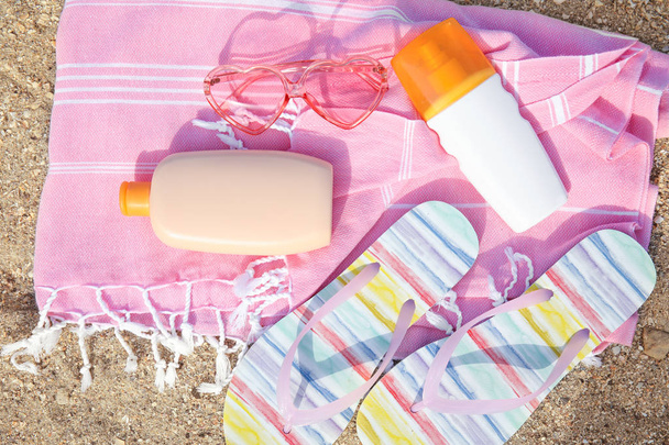 Flat lay composition with bottles of sun protection body cream on sand beach, space for design - Zdjęcie, obraz