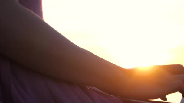 Meisje bij zonsondergang in de zon Typ tekst op een laptop. - Video