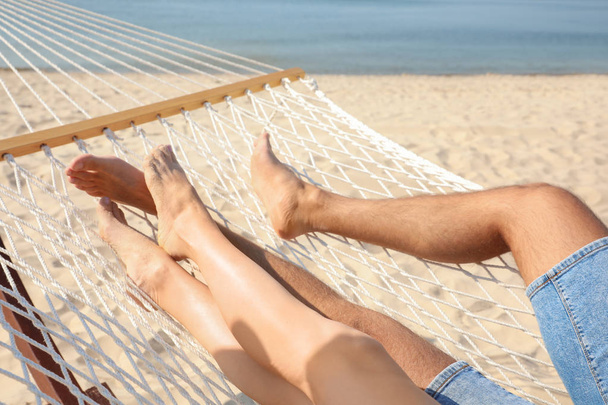 Young couple relaxing in hammock on beach, closeup - Photo, Image