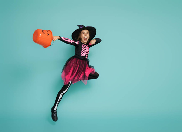 little witch on turquoise background - 写真・画像