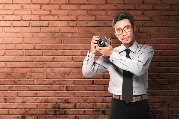 Asian businessman holding the camera on his hand standing - Fotó, kép