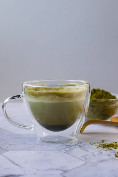 Matcha green latte tea with coconut milk. This latte is a tasty way to enjoy the energy and health benefits of a match. Matcha is a green tea leaf powder filled with antioxidants. Vertical orientation - Zdjęcie, obraz