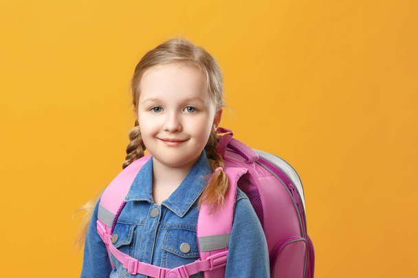 Portrait of a little girl schoolgirl with a backpack on a yellow background. Back to school. The concept of education. Copy space. - Fotó, kép