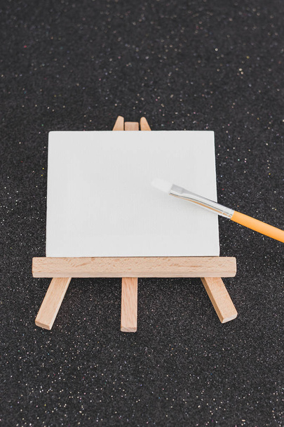 mini blank canvas and paintbrush with copyspace - Fotó, kép