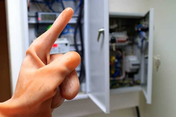 the index finger in the dielectric rubber glove is raised up - Photo, Image