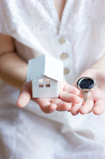 Κοριτσάκι που κρατάει το μικρό σπίτι και το κλειδί στα χέρια - Φωτογραφία, εικόνα