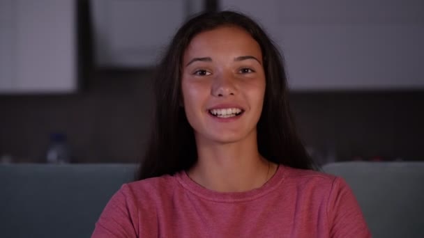 smiling brunette with long loose hair talks in dark room - Video, Çekim