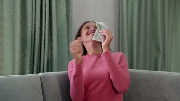 young beautiful woman in pullover catches falling banknotes - Кадры, видео