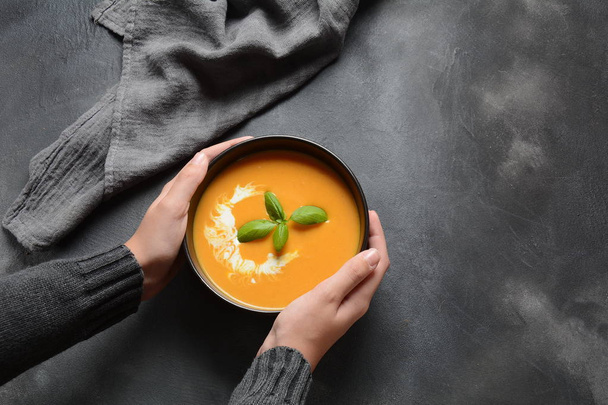 Bowl of pumpkin and carrot cream soup in hands. Autumn hot vegan soup concept - Fotoğraf, Görsel