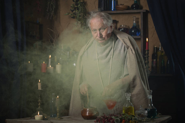 elderly alchemist monk brews  magic potion - Foto, Imagem
