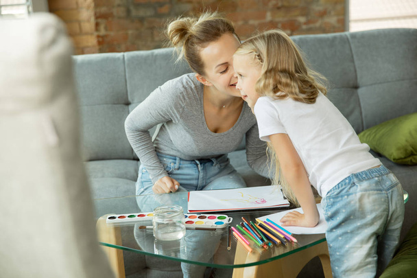Teacher and little girl, or mom and daughter. Homeschooling concept - Foto, afbeelding