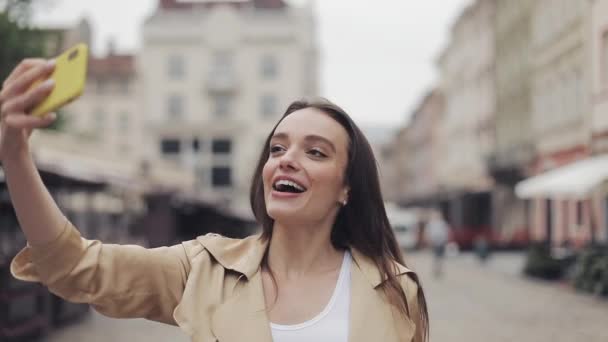 Beautiful Happy Young Lady Making a Video call Smiling Talking Walking Relaxed Showing City on the Street Background. - Felvétel, videó