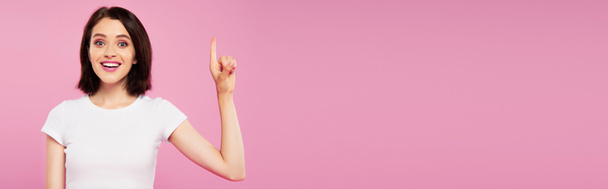πανοραμικό σφηνάκι όμορφη χαμογελαστή κορίτσι δείχνοντας ιδέα χειρονομία απομονωθεί σε ροζ - Φωτογραφία, εικόνα