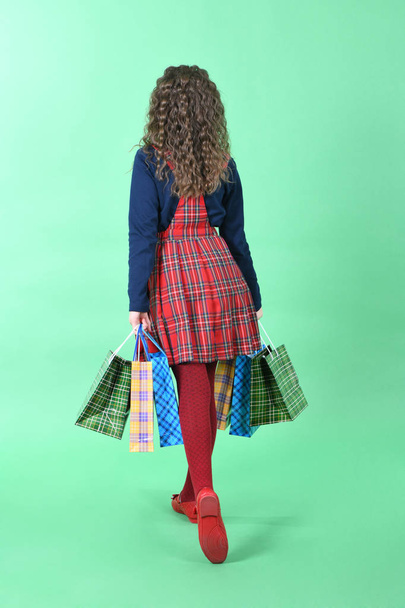 Kind mit einer Verpackung kariert Textur isoliert auf weißem Hintergrund. Mädchen mag Einkaufen im Verkauf Saison. Weihnachtsgeschenk, Einkaufen.  - Foto, Bild