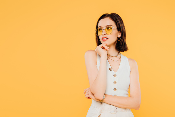 dreamy fashionable girl in sunglasses looking away isolated on yellow - Fotografie, Obrázek