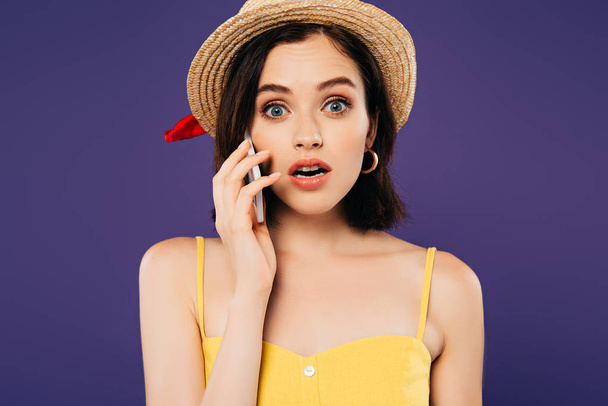 shocked girl in straw hat talking on smartphone isolated on purple - Foto, Bild