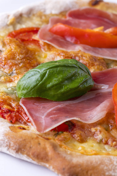 detail of a pizza with ham and basil  - Fotó, kép
