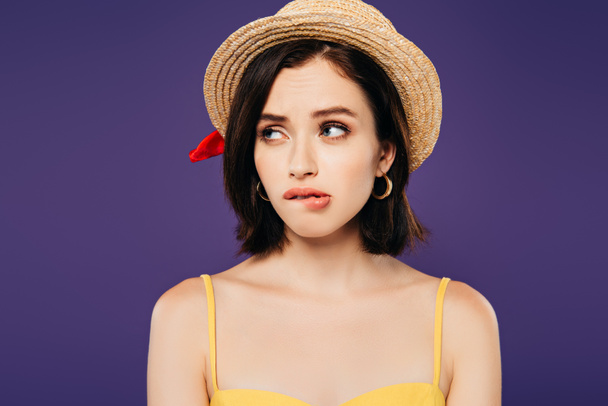 confused girl in straw hat looking away isolated on purple - Photo, Image