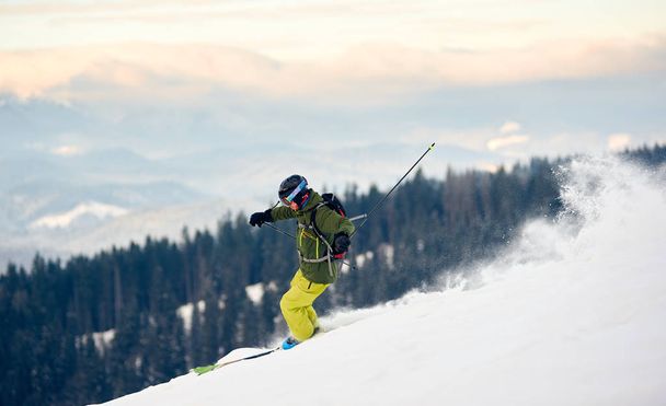 Sırt çantalı usta kayakçı yamaçtan aşağı doğru koşuyor. - Fotoğraf, Görsel