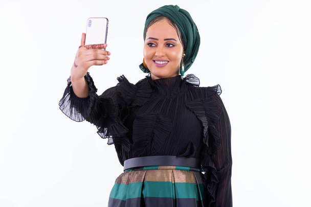 Jovem feliz bela mulher muçulmana africana tomando selfie
 - Foto, Imagem