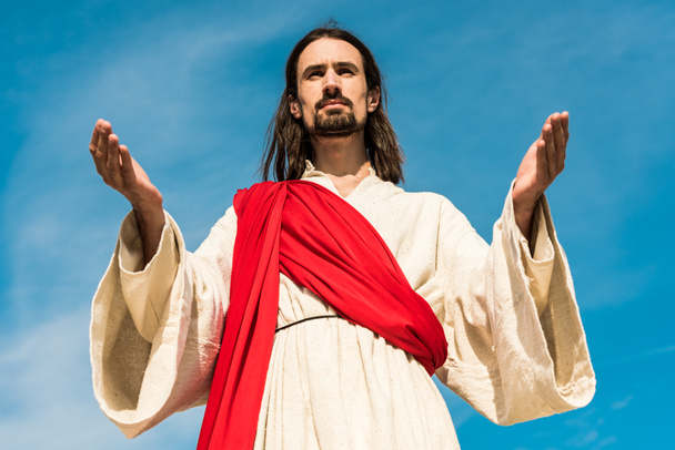low angle view of bearded man with outstretched hands against sky  - Photo, Image
