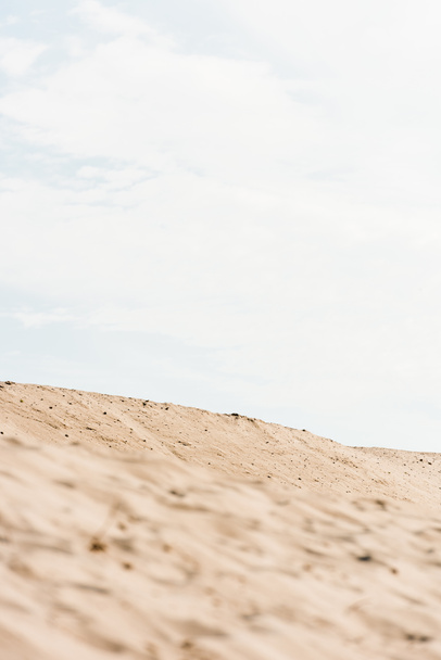 селективный фокус волнистого и золотого песка против неба с облаками в пустыне
  - Фото, изображение