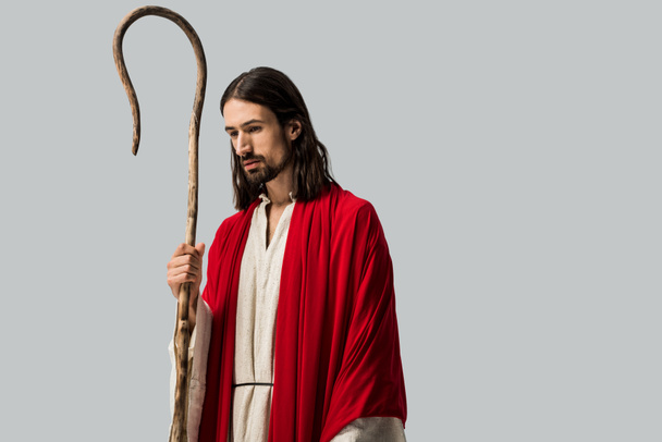 smutny człowiek w Jezusie szatę trzymanie drewnianej trzciny na szaro - Zdjęcie, obraz