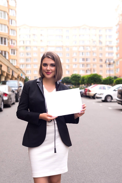 Business woman holding paper with place for your text. Smiling and successful lady. - Photo, Image