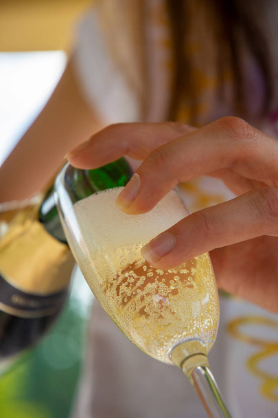 Pouring sparkling wine into a glass - Photo, Image