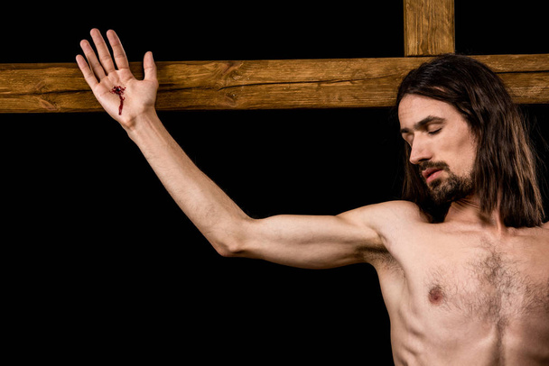 Jesús crucificado en cruz de madera aislado en negro
  - Foto, Imagen