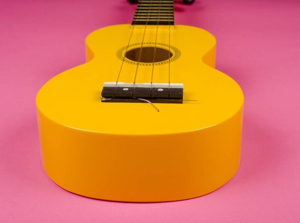 Тіло яскраво-жовтого укулеле гітари
 - Фото, зображення