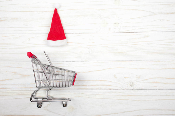 Shopping cart and a Santa hat - Foto, Imagen