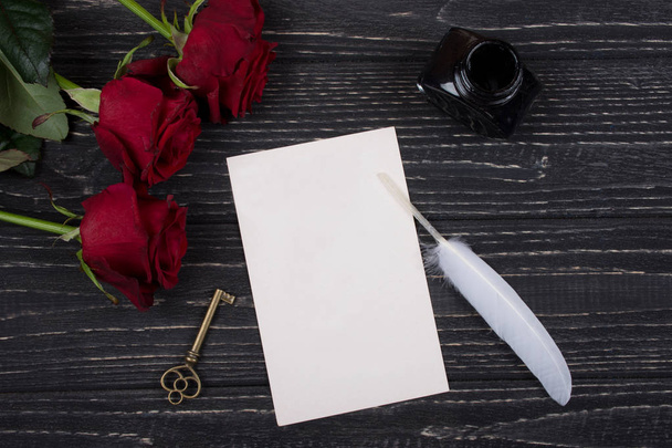 Red roses, a key, a card, a feather and an inkpot - Photo, Image