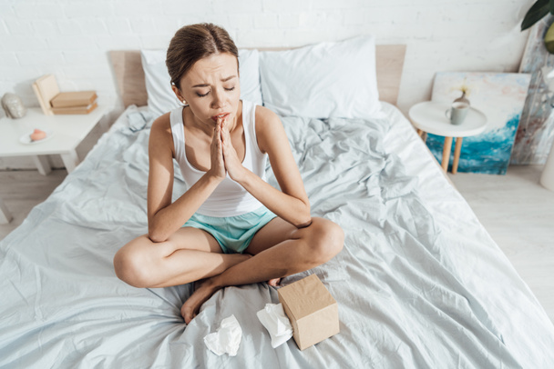 stressed young woman sitting on bed and showing please getsure - Photo, Image