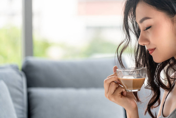 asiatische junge Frau trinkt Kaffee am Morgen. - Foto, Bild