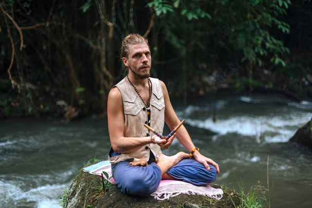 Práctica de yoga y meditación en la naturaleza. Hombre practicando cerca del río
 - Foto, Imagen