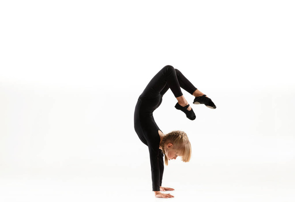 Маленькая гимнастка, практикующая на белом фоне
 - Фото, изображение