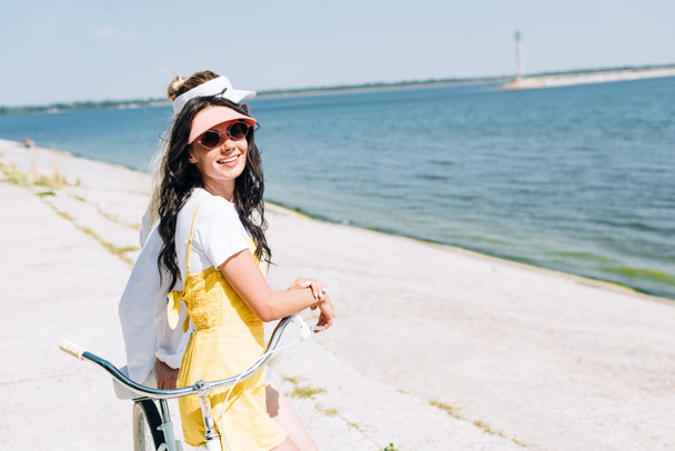 boční pohled na dívky s cyklistickou jízdním kolem řeky v létě - Fotografie, Obrázek