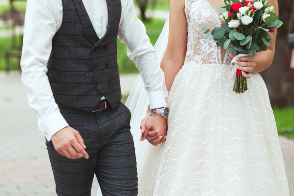The bride and groom are gently holding hands at the wedding, close-up - Foto, Bild