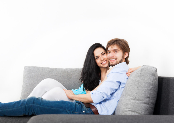 Young couple sitting on a sofa - Фото, изображение