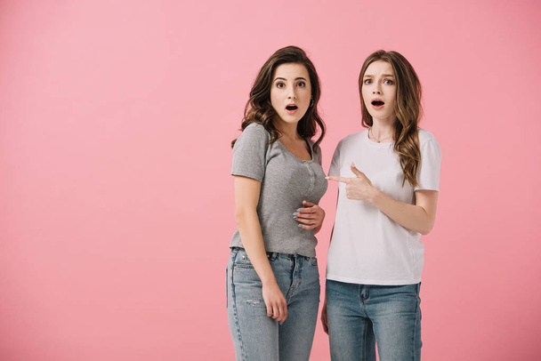 attractive and shocked women in t-shirts looking at camera isolated on pink - Fotoğraf, Görsel