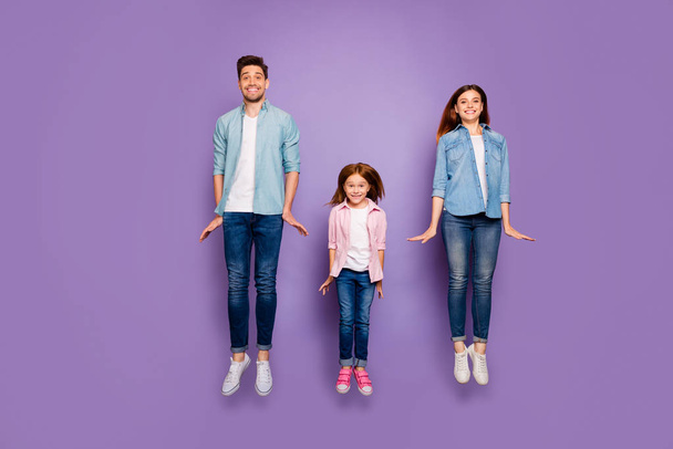 Full size photo of three jumping high family members wear casual clothes isolated purple background - Foto, Imagen