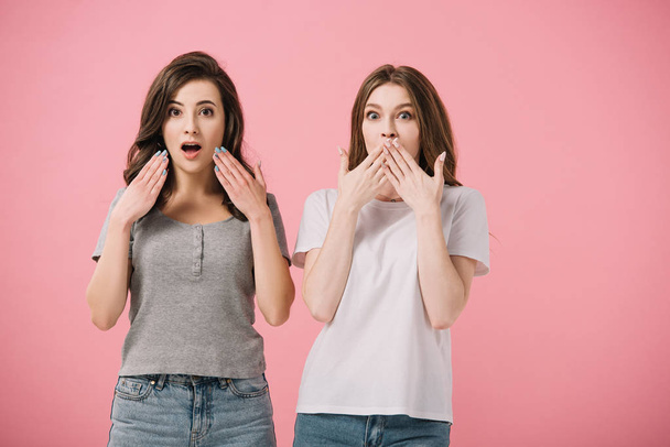 attractive and shocked women in t-shirts looking at camera isolated on pink - Foto, imagen